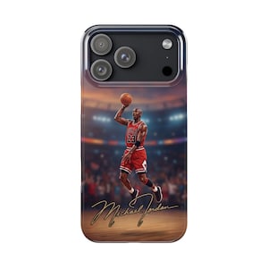 Op de afbeelding: Een smartphonehoesje met een afbeelding van een basketballer in een rood shirt met nummer 23, die in de lucht een basketbal schiet. Het ontwerp bevat een wazige stadionachtergrond en de gouden cursieve handtekening Michael Jordan.