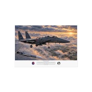 May include: A print titled Formation Approach featuring a grey F-15E Strike Eagle fighter jet in flight against a sunset sky with clouds. The aircraft displays the tail code LN and number 16201. A missile is visible on the wing of another aircraft.