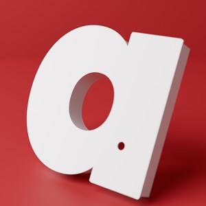 May include: A three-dimensional white lowercase letter a with a small circular dot positioned to the lower right of the central opening. The letter features a clean, sans-serif typeface design and is set against a solid, vibrant red background.