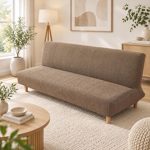 May include: A brown sofa cover featuring a textured geometric pattern. The fabric is fitted over a backless sofa frame with light-colored wooden legs. The cover has a consistent, repeating embossed design across the entire surface area.