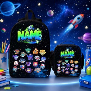 May include: A black backpack and matching lunch bag featuring a space-themed background with stars and planets. Both items display the word NAME in large green letters, a small rocket ship, and a collection of colorful robot character illustrations.