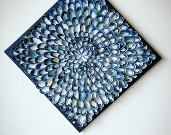 May include: A square canvas painting with a blue and white abstract design. The design is made up of many small, overlapping shapes that create a swirling, organic pattern.