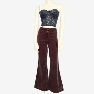 May include: A black lace corset top and brown corduroy flared pants displayed on a mannequin. The corset has a sweetheart neckline and is embellished with delicate lace. The pants have a high waist and a wide leg.