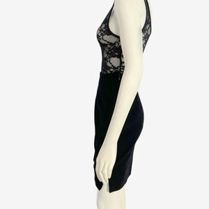 May include: A black dress with a lace bodice and a pencil skirt. The dress is sleeveless with a V-neckline and a fitted silhouette. The lace detailing on the bodice adds a touch of elegance to the overall design.