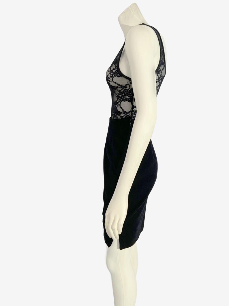 May include: A black dress with a lace bodice and a pencil skirt. The dress is sleeveless with a V-neckline and a fitted silhouette. The lace detailing on the bodice adds a touch of elegance to the overall design.