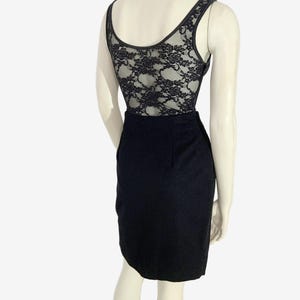 May include: Black bodysuit with a lace back and a pencil skirt. The sleeveless top has a scoop neckline and a black lace back. The skirt is a classic pencil style, made of a dark fabric.
