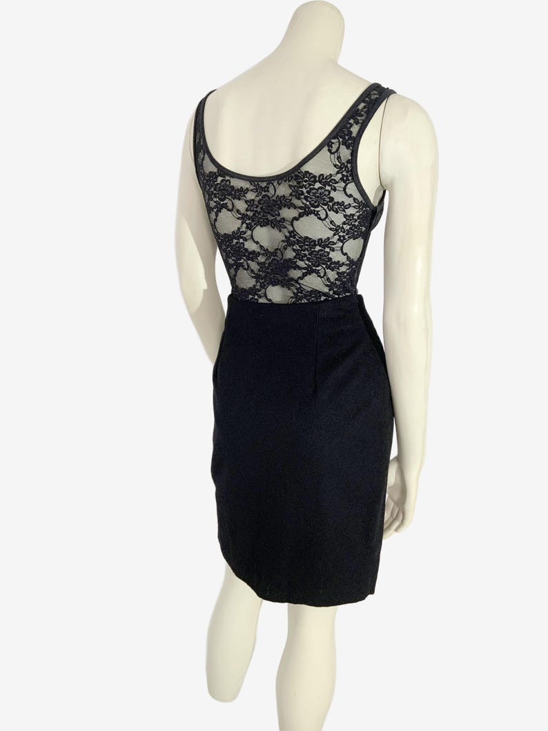 May include: Black bodysuit with a lace back and a pencil skirt. The sleeveless top has a scoop neckline and a black lace back. The skirt is a classic pencil style, made of a dark fabric.