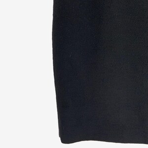 May include: A close-up shot of a black, textured fabric. The fabric appears to be a thick material, possibly wool or a similar textile. The image is well-lit, highlighting the texture and color of the material.