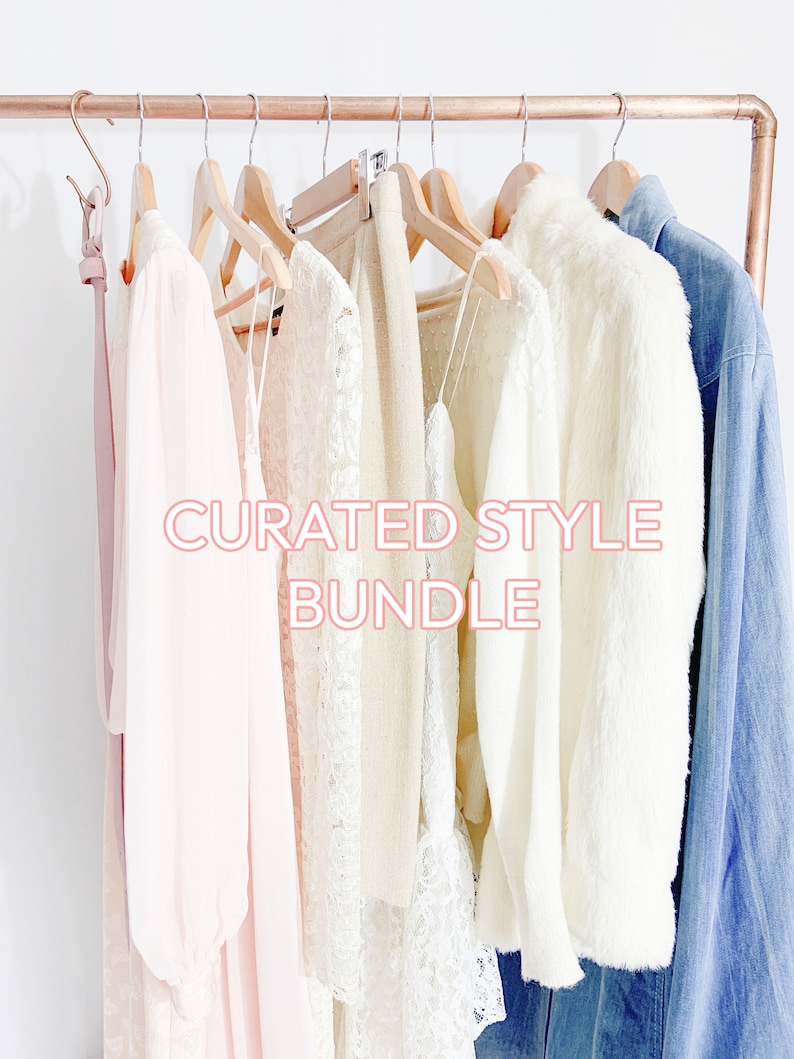 May include: A curated style bundle of clothing items hanging on a copper pipe rack. The bundle includes a white lace top, a white sweater, a white fur jacket, a light blue denim jacket, and a pink dress.