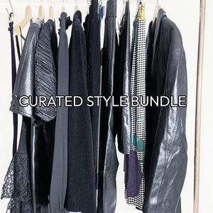 May include: A curated style bundle of clothing items hanging on a rack. The bundle includes a black lace dress, a black leather jacket, a black corduroy jacket, a black leather skirt, a black and white patterned skirt, and a black and green patterned dress. The text "CURATED STYLE BUNDLE" is printed on the rack.