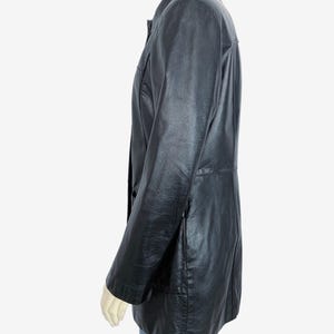 May include: A black leather jacket with a collared neckline and button closure. The jacket has long sleeves and a tailored fit. The jacket is approximately 30 inches long.