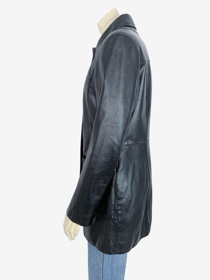 May include: A black leather jacket with a collared neckline and button closure. The jacket has long sleeves and a tailored fit. The jacket is approximately 30 inches long.