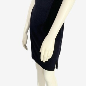 May include: A navy blue dress with a lace bodice and a fitted skirt. The dress is displayed on a mannequin. The skirt has a slit on the side.