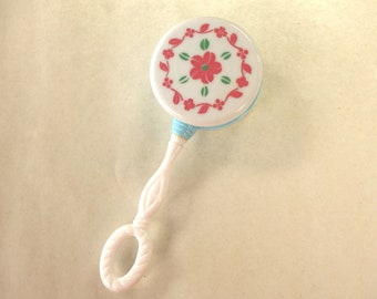 Chocalho de brinquedo vintage: tambor azul e branco com flores rosas, plástico rígido, década de 1960