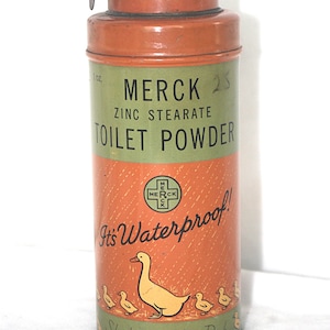Può includere: Latta vintage di polvere per toilette Merck Zinc Stearate. Il contenitore cilindrico è arancione e verde con la scritta "MERCK ZINC STEARATE TOILET POWDER". Presenta un'illustrazione di anatra e anatroccoli e le parole "It's Waterproof!"