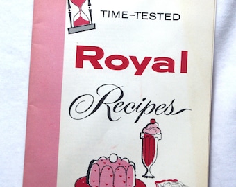 May include: A vintage cookbook, "Royal Recipes", with a pink spine. The cover displays an hourglass illustration, the words "TIME-TESTED" and "Royal Recipes" in red and black. Illustrations of desserts, including a cake and milkshake, are also shown.