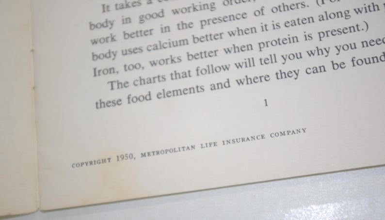 May include: Open book page with text about food elements and nutrition. The text includes the phrase "body uses calcium better" and "Iron, too, works better." The copyright reads "COPYRIGHT 1950, METROPOLITAN LIFE INSURANCE COMPANY."
