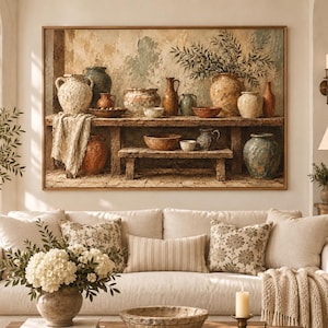 May include: A large rectangular framed wall art print depicting a rustic wooden table filled with various ceramic pottery, bowls, and a leafy branch. The scene features earthy tones of beige, brown, and muted blue, showcasing a collection of vessels.