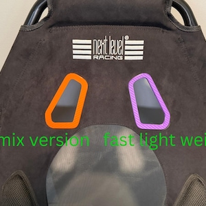 May include: A black Next Level Racing seat featuring a white logo at the top, an orange harness pass-through, and a purple harness pass-through. The text "Remix version" and "fast light weight" is printed in green across the lower section.