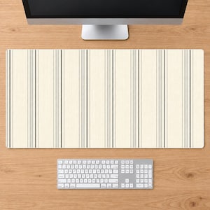 May include: A rectangular desk mat featuring a cream-colored background with a repeating pattern of vertical stripes in varying widths of charcoal gray and light gray, creating a structured, linear design across the entire surface of the mat.