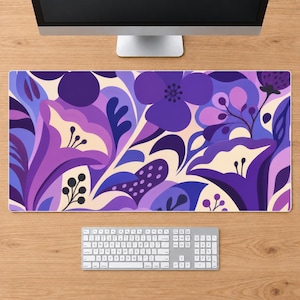 May include: A rectangular desk mat featuring a vibrant floral pattern in shades of purple, lavender, and cream. The design includes stylized flowers, rounded petals, and small berry-like clusters arranged in a dense, flowing composition.