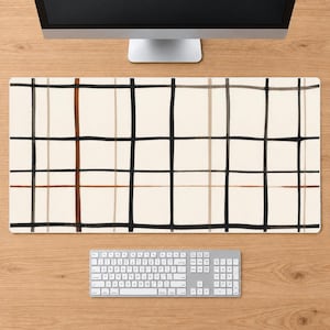 Könnte beinhalten: Eine rechteckige Schreibtischunterlage mit cremefarbenem Hintergrund und einem Gittermuster aus sich kreuzenden Linien. Das Design besteht aus dünnen und dicken schwarzen Linien sowie Akzentlinien in Braun- und Beigetönen im Karomuster.