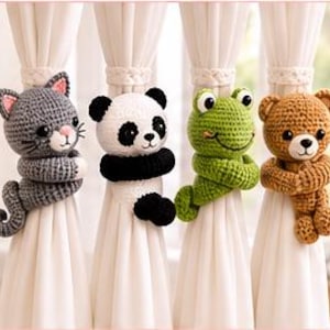Puede incluir: Cuatro alzapaños de cortina de ganchillo con diseños de animales: un gato gris, un panda blanco y negro, una rana verde y un oso marrón. Cada figura de peluche tiene brazos largos envueltos alrededor de cortinas blancas para sujetarlas.