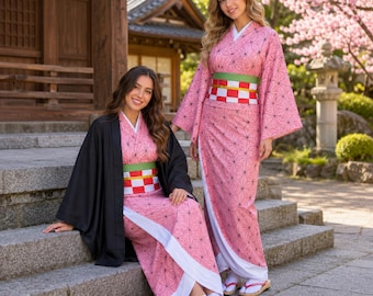 May include: Two pink kimono-style robes featuring a black geometric hemp leaf pattern, white trim, and a wide obi belt with green, white, and red checkered sections. One robe is worn with a solid black haori jacket and white tabi socks with sandals.