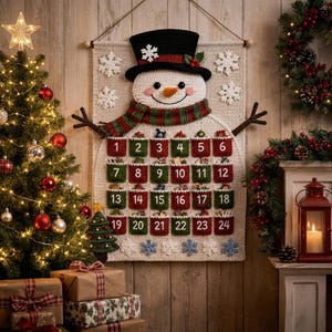 May include: A crocheted snowman advent calendar wall hanging featuring a black top hat, a green and red striped scarf, and twenty-four numbered pockets in red and green. The cream-colored background is decorated with white crocheted snowflakes.