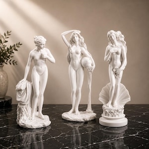 Könnte beinhalten: Drei weiße, matte Statuen weiblicher Figuren in klassischen Posen. Die linke Figur steht neben drapiertem Stoff, die mittlere hält ein Wassergefäß mit fließender Flüssigkeit und die rechte Figur steht auf einem Sockel in Muschelform.
