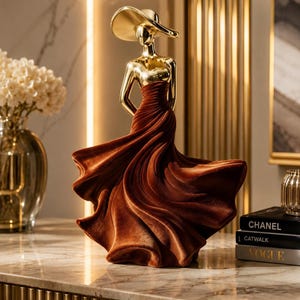 Lyxig kvinnofigur, guldfärgad damskulptur, elegant heminredning, modern konststaty, glamorös vardagsrumspresent