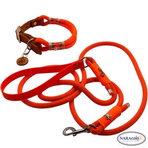 May include: A bright neon orange dog collar and matching leash set. The collar features brown leather accents, silver hardware, and a round wooden tag. The leash is made of thick braided rope with a flat handle, silver clips, and decorative charms.