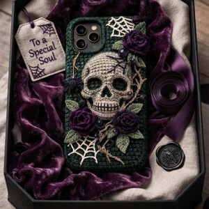 May include: A dark green crocheted phone case featuring a central beige skull, purple crocheted roses, green leaves, and white spiderweb accents. A beige gift tag with the text "To a Special Soul" and a black wax seal with a bird design are included.