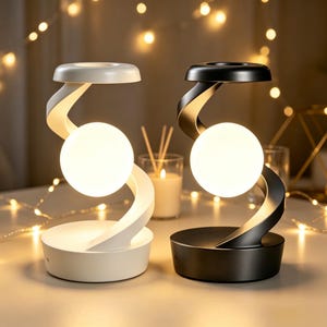 Peut inclure: Deux lampes de table avec un cadre incurvé en forme de S, l'une en blanc mat et l'autre en noir mat. Chaque lampe présente une ampoule sphérique lumineuse centrale suspendue dans le cadre, reposant sur une base circulaire plate.