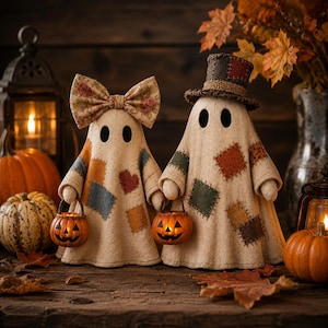Puede incluir: Dos figuras de fantasmas de tela con detalles de patchwork cosidos. Un fantasma lleva un lazo floral, el otro un sombrero de copa. Ambas figuras sostienen pequeños cubos de calabaza naranjas iluminados. Los fantasmas son de color beige.