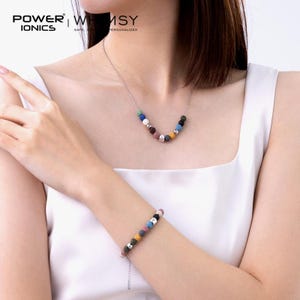 May include: A silver chain necklace and a matching bracelet, both featuring a series of small, multi-colored porous beads and smooth metallic silver spheres. The necklace and bracelet are displayed together, showcasing a consistent design of alternating textured and polished elements.