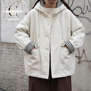May include: An off-white hooded jacket featuring a button-front closure, long sleeves with black and white gingham cuffs, and two large front patch pockets. The interior lining and hood edge display a matching black and white gingham pattern.