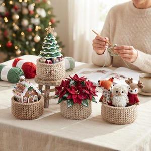 May include: A collection of crocheted holiday decorations including a light-up Christmas tree, a gingerbread house, a red poinsettia plant, and three small stuffed animals—a fox, an owl, and a deer—all displayed in round beige baskets.