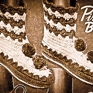 Può includere: Un paio di stivali da pirata all'uncinetto fatti a mano, nei toni del marrone e del crema. Gli stivali presentano un design strutturato, bordi smerlati e dettagli con pompon. Le parole "Pirate Boots" sono scritte in un carattere decorativo.