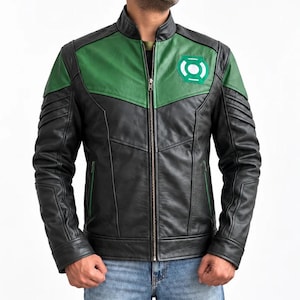 May include: A black and green leather jacket featuring a stand-up collar, a full-length front zip, and a circular Green Lantern emblem on the left chest. The design includes paneled construction with ribbed detailing on the upper sleeves.