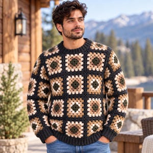 May include: A long-sleeve sweater constructed from individual crochet granny squares in a repeating pattern of dark charcoal, beige, tan, and forest green. The garment features a ribbed crew neckline, ribbed cuffs, and a ribbed hemline.