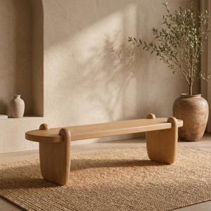 May include: A light-toned wooden bench featuring a smooth, elongated rectangular seat with rounded ends. The bench is supported by two thick, curved leg structures that extend slightly above the seat surface as rounded decorative accents.