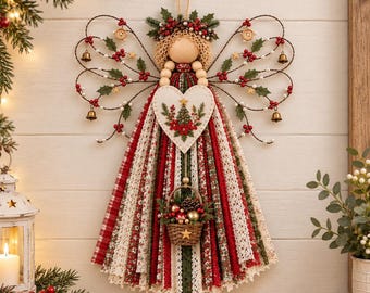 Puede incluir: Un adorno colgante de ángel con cabeza de cuenta de madera, halo de hilo color crema y alas de alambre adornadas con bayas rojas, hojas de acebo verdes, pequeñas campanas doradas y botones de madera. El vestido está hecho de tiras de tela.