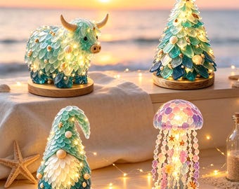 Puede incluir: Cuatro adornos decorativos iluminados sobre bases de madera: un toro color cerceta, un árbol de Navidad cónico, un gnomo y una medusa, todos hechos de piezas de vidrio marino translúcido azul, verde y morado, con pequeños caracoles blancos.
