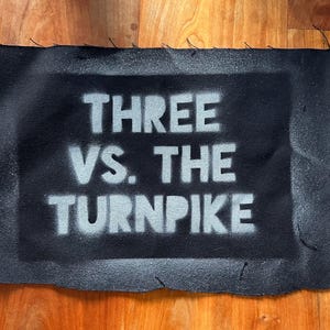 May include: Black fabric patch with white text that reads "THREE VS. THE TURNPIKE".