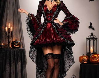 May include: A high-low dress in deep burgundy and black featuring long flared sleeves with lace trim, a structured collar, and a front bodice with decorative bows. The garment is paired with black lace-topped stockings and black high-heeled shoes.