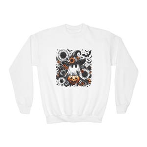 May include: A white long-sleeve sweatshirt featuring a central graphic print of a ghost wearing a witch hat, surrounded by sunflowers, small flowers, and flying bats, with an orange jack-o'-lantern pumpkin positioned at the base of the ghost.