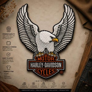 May include: An embroidered iron-on patch featuring a white eagle with spread wings perched atop a black and orange Harley-Davidson Motor Cycles shield logo. The patch includes detailed white stitching for the feathers and yellow talons.