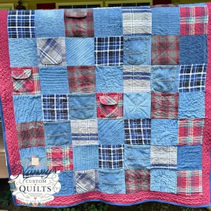Könnte beinhalten: Ein Patchwork-Quilt aus Quadraten aus blauem Denim und verschiedenen karierten Flanellstoffen. Der Quilt verfügt über mehrere integrierte Jeanstaschen und ist mit einem einfarbigen, dunkelrosa Rand versehen. Die Decke hat eine gesteppte Textur.