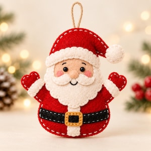 Könnte beinhalten: Ein Filz-Weihnachtsmann-Anhänger mit roter Mütze und weißem Bommel, weißem Bart, schwarzem Gürtel mit goldener Schnalle und roten Fäustlingen. Die Figur hat ein beiges Gesicht mit schwarzen Augen und rosa Wangen sowie eine Schlaufe aus Juteschnur.